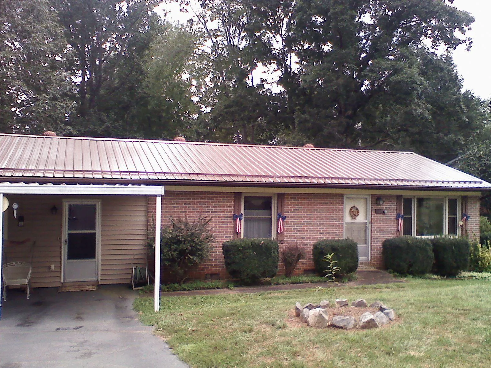 Bronze metal roof and carport on a brick ranch home — Roof Repair work by our crew in Allendale